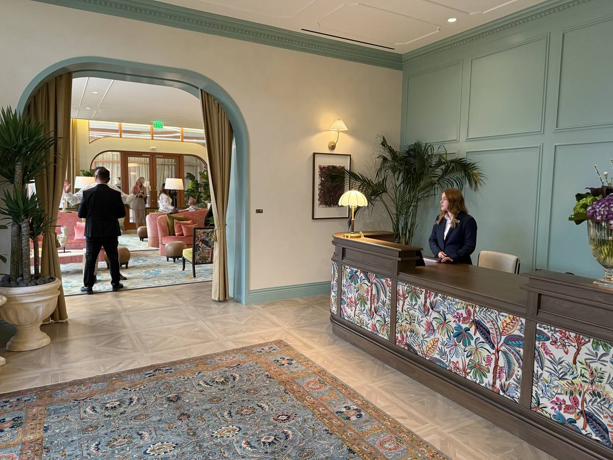 Lobby con mostrador de concierge en tapiz floral, arcada clásica y alfombra persa — NoMad Wynwood Miami