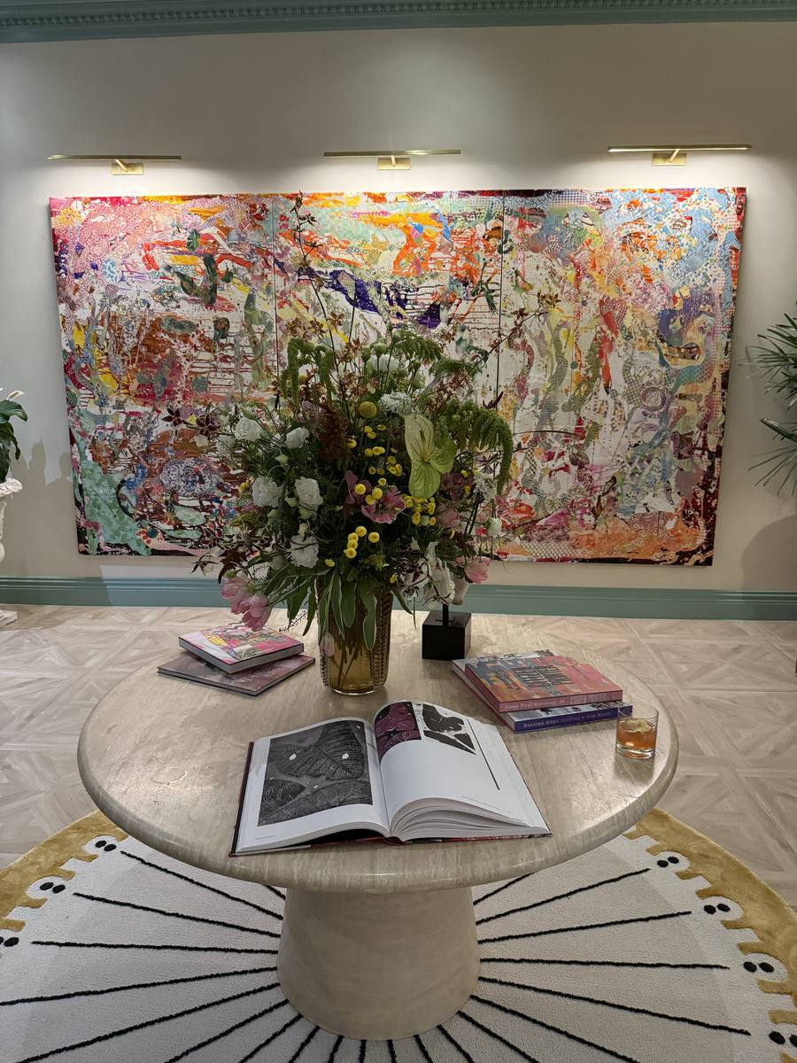 Arte contemporáneo y mesa auxiliar redonda con libros de diseño — NoMad Wynwood lobby