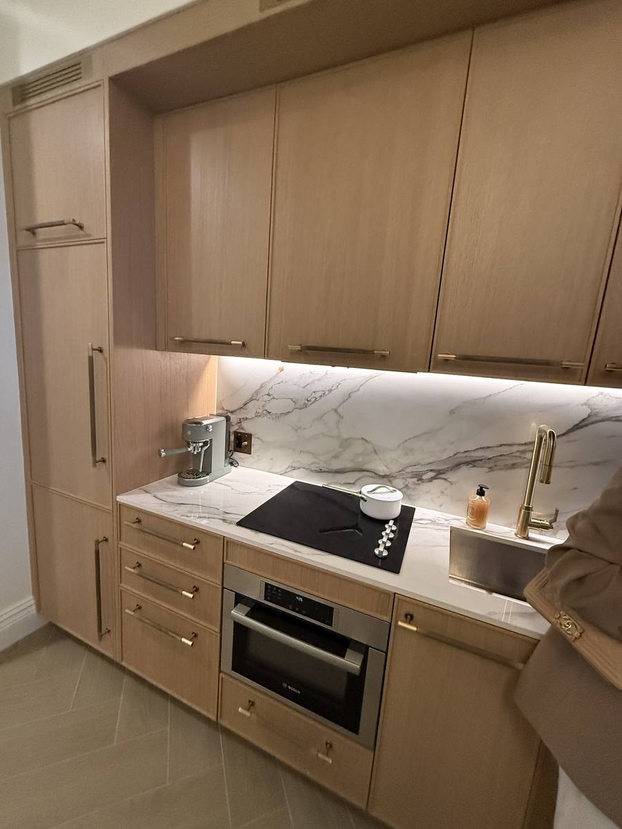 Detalle de backsplash de mármol y cooktop en cocina de NoMad Wynwood