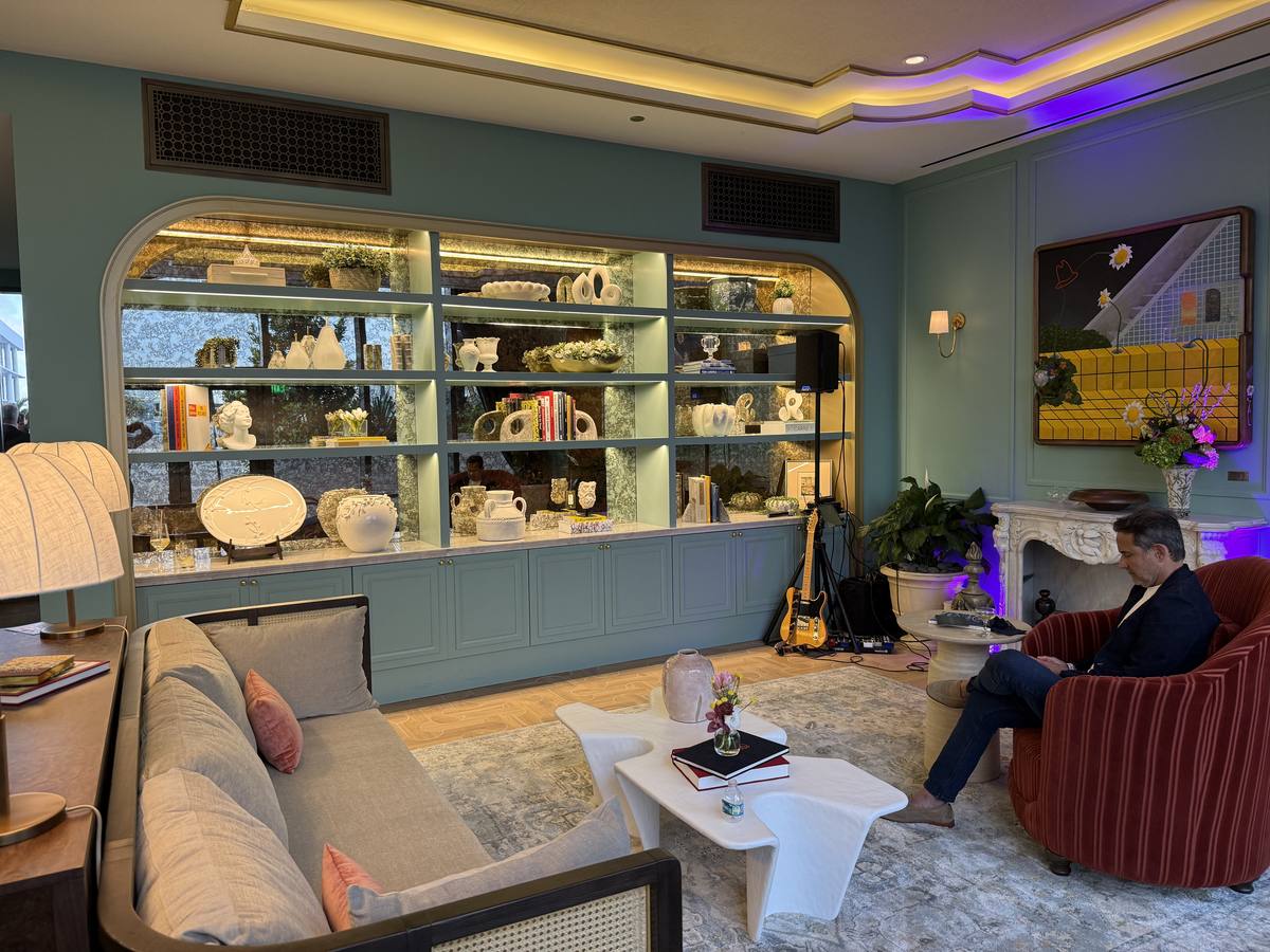 Sala de estar con built-ins color verde salvia, sofá gris y chimenea — Casa Tua Residences